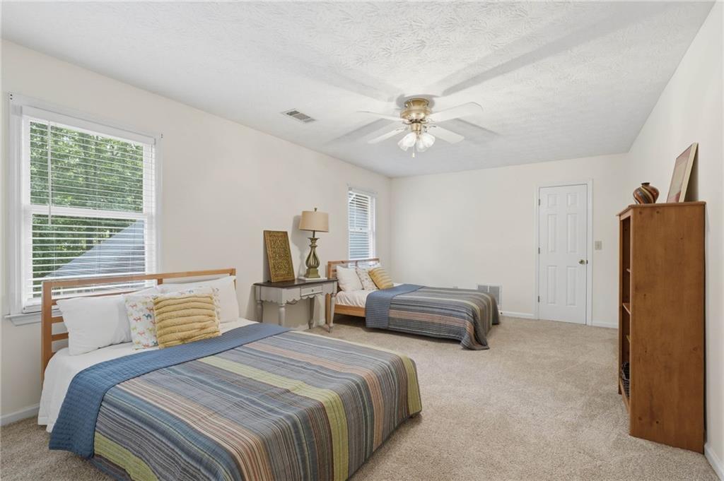4891 Bill Cheek Road Auburn, GA 30011 - Photo 40 of 99 a bedroom with a bed and a chandelier