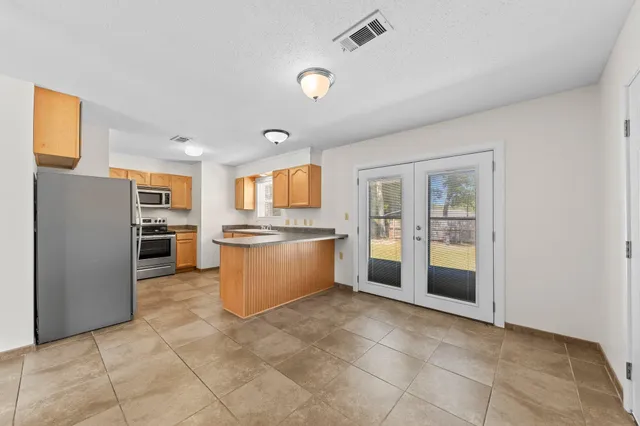 a large kitchen with a large counter top stainless steel appliances and cabinets