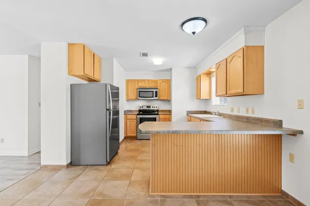 a kitchen with stainless steel appliances granite countertop a refrigerator and a stove