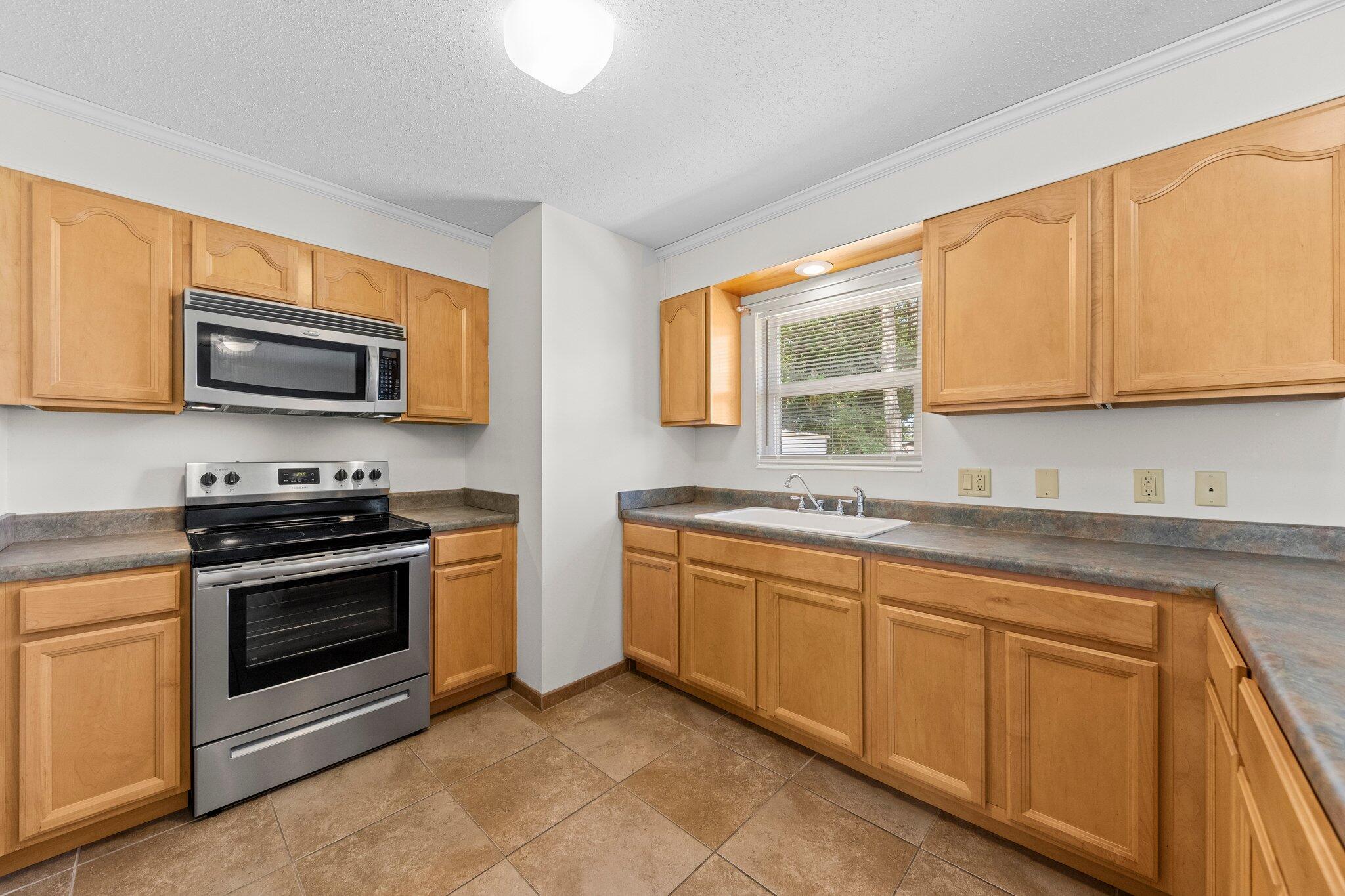 309 23rd Street Niceville, FL 32578 - Photo 13 of 33 a kitchen with stainless steel appliances granite countertop a stove a sink and a microwave