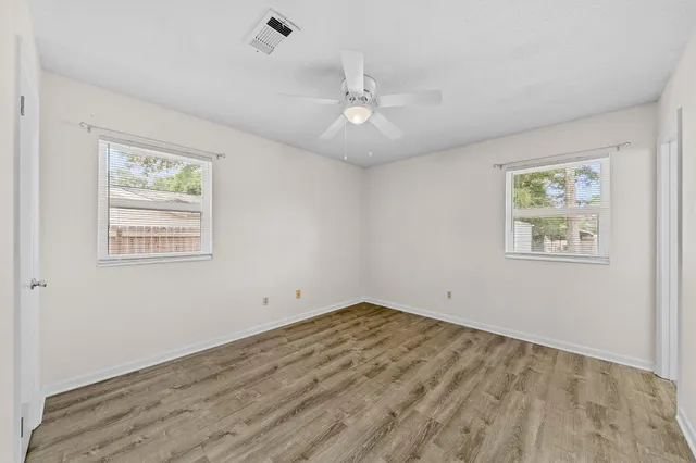 a view of empty room with wooden floor