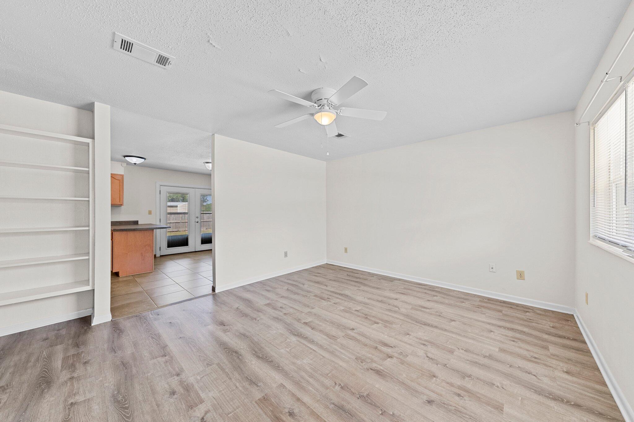 309 23rd Street Niceville, FL 32578 - Photo 5 of 33 wooden floor in an empty room with a window