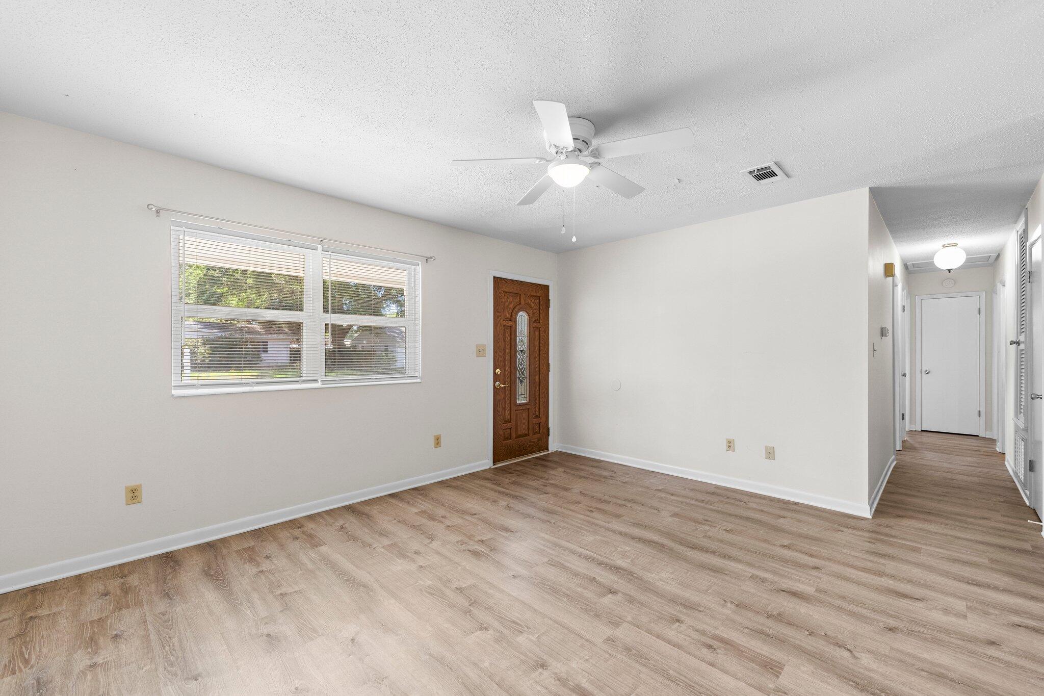 309 23rd Street Niceville, FL 32578 - Photo 6 of 33 a view of an empty room with wooden floor and a window