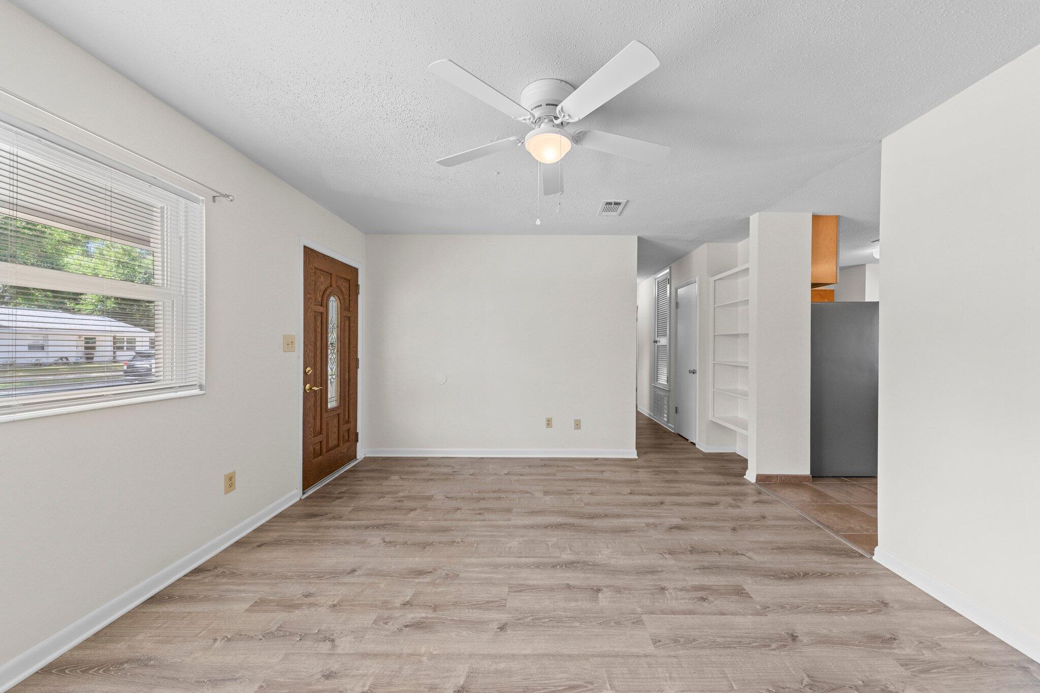 309 23rd Street Niceville, FL 32578 - Photo 7 of 33 wooden floor in an empty room with a window