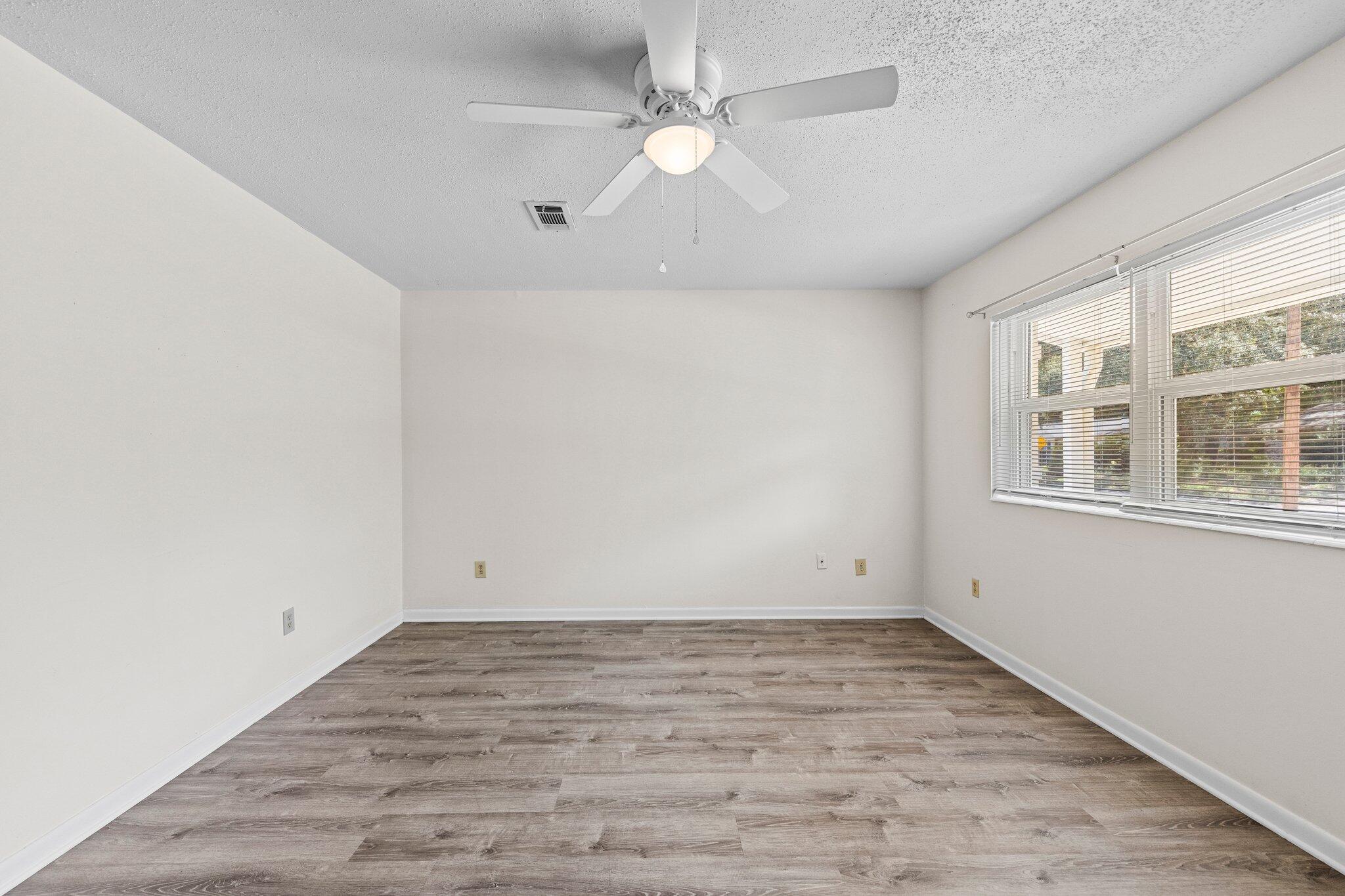 309 23rd Street Niceville, FL 32578 - Photo 8 of 33 wooden floor in an empty room with a window