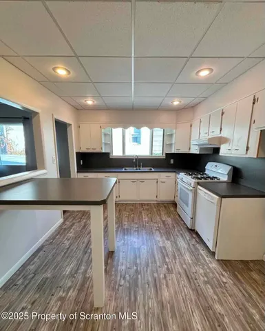 a large kitchen with stainless steel appliances granite countertop a stove a sink dishwasher and a oven with cabinets