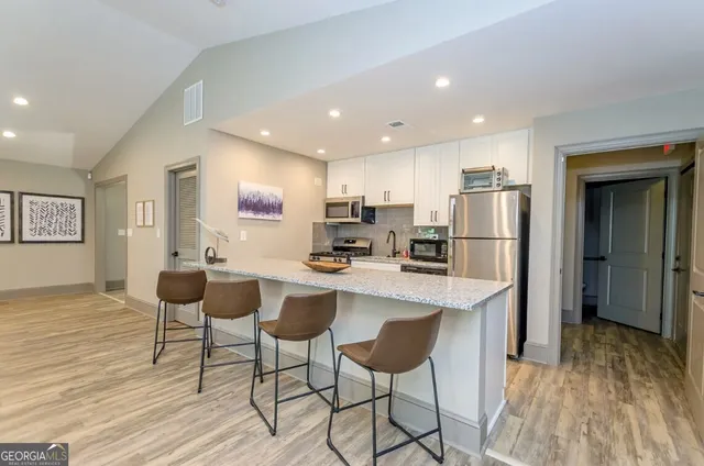 a kitchen with stainless steel appliances kitchen island granite countertop a refrigerator and a stove top oven