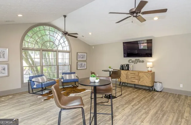 a living room with furniture a flat screen tv and a large window