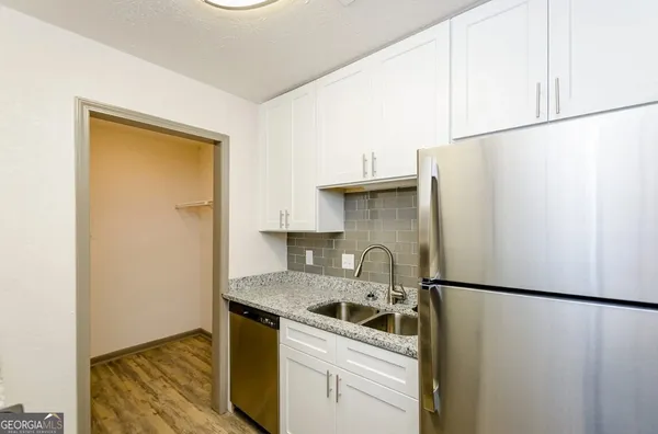 a kitchen with a refrigerator sink stove and cabinets