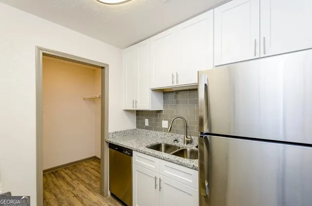 a kitchen with a refrigerator sink stove and cabinets