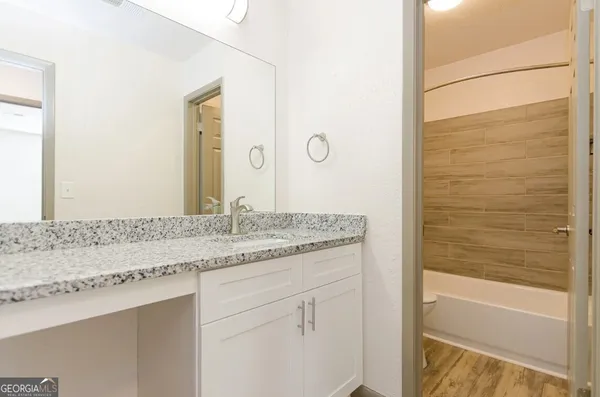 a bathroom with a granite countertop sink and a mirror