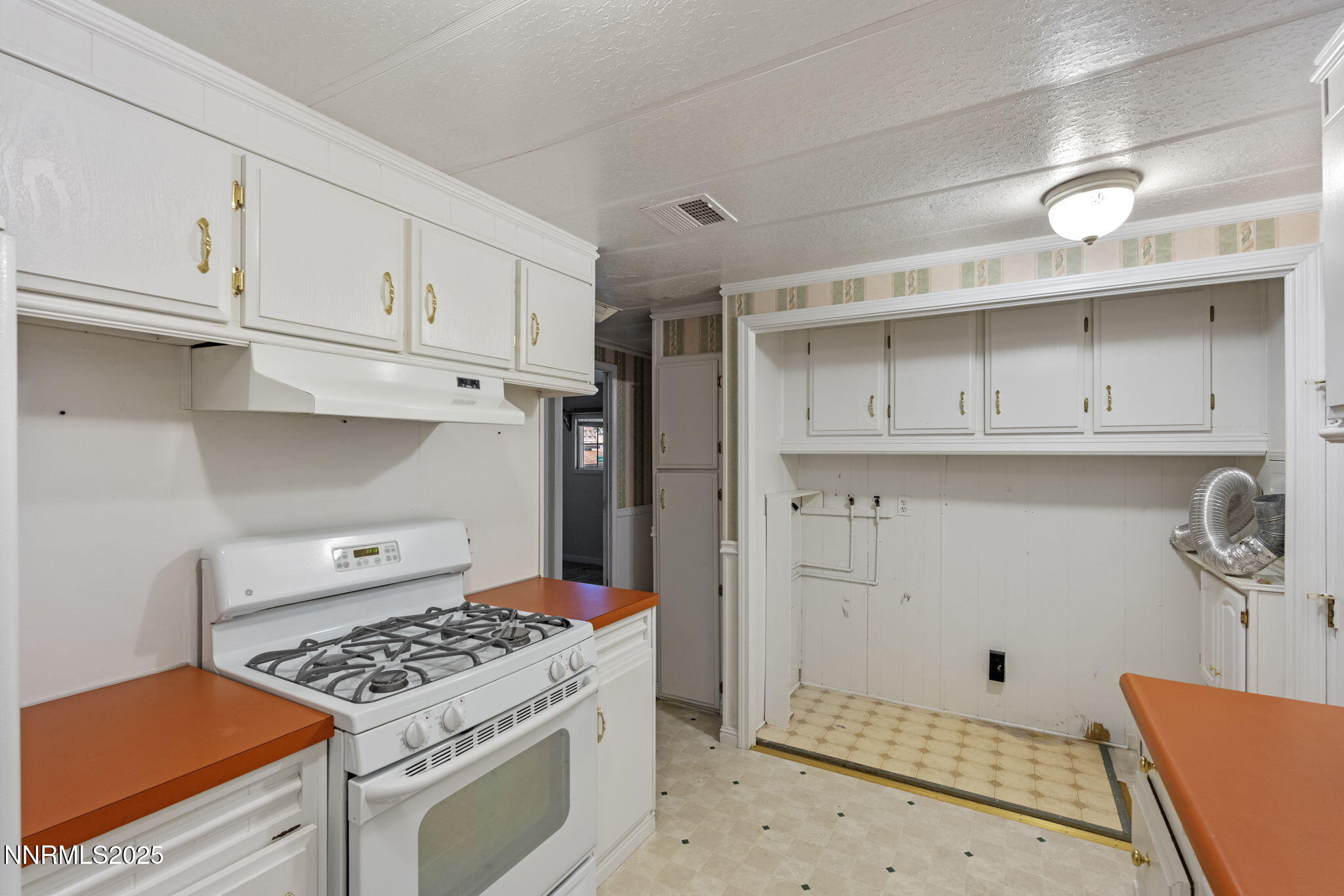180 Staci Way Sun Valley, NV 89433 - Photo 21 of 71 a kitchen with white cabinets and appliances