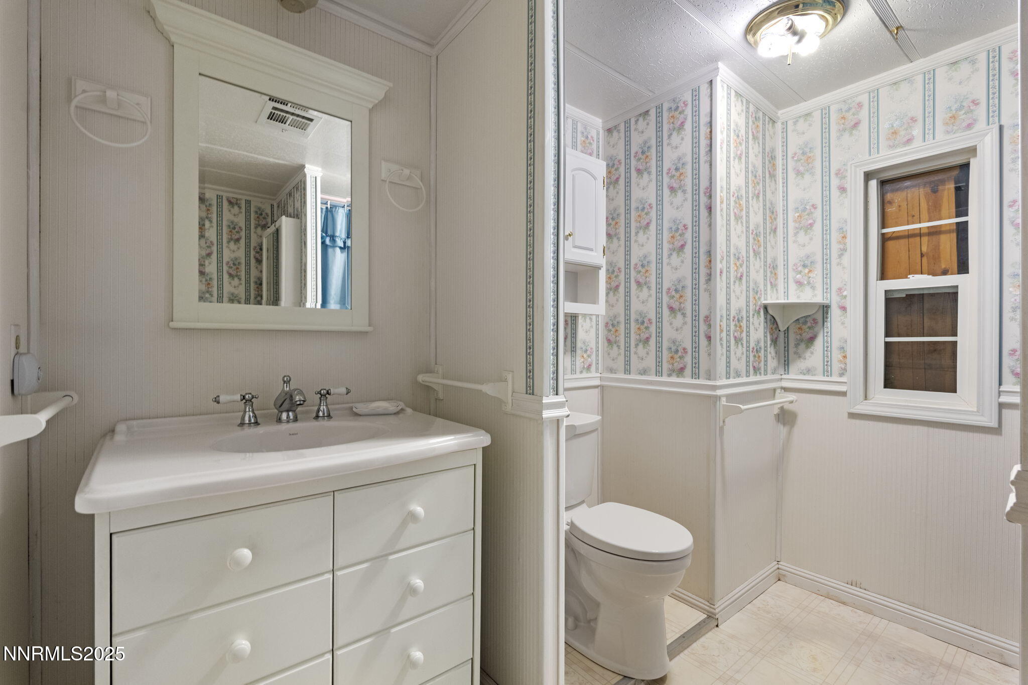180 Staci Way Sun Valley, NV 89433 - Photo 33 of 71 a bathroom with a toilet a sink a mirror a window and vanity
