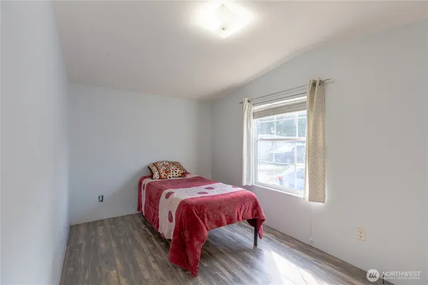 a bed sitting in a bedroom next to a window