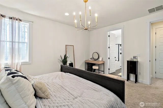 a bedroom with a bed a chandelier and a window
