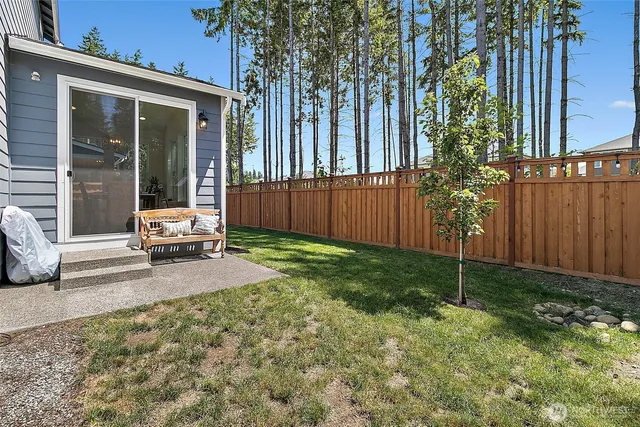 a view of a backyard with table and chairs and a large tree