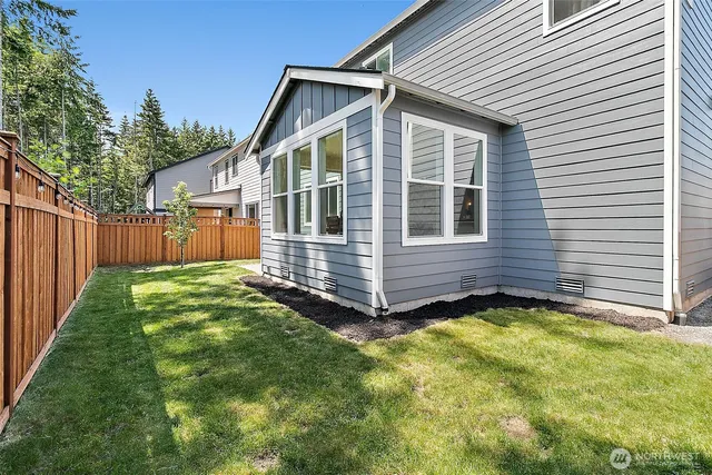 a view of a house with a yard and wooden fence