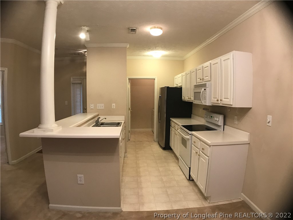 522 Lionshead Road, Unit 3 Fayetteville, NC 28311 - Photo 4 of 20 a kitchen with stainless steel appliances a sink stove and refrigerator