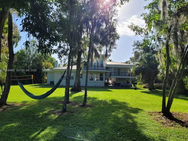 a view of a swimming pool and lounge chairs in back yard of the house