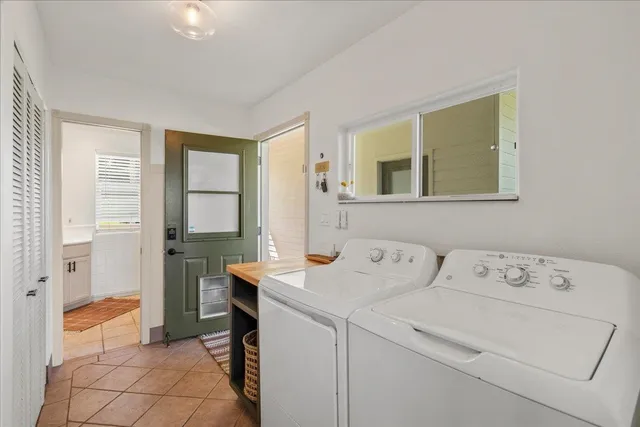 a view of washer and dryer with bathroom in the background