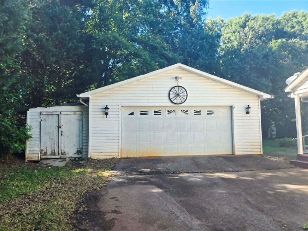 202 Keith Lane Seneca, SC 29678 - Photo 2 of 23 A classic white garage door and adjacent shed provide ample storage and utility.