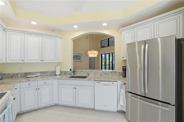 a kitchen with a refrigerator sink and cabinets