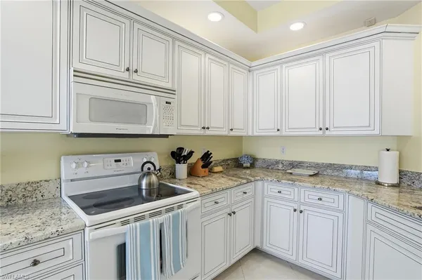 a kitchen with stainless steel appliances granite countertop white cabinets a sink and dishwasher
