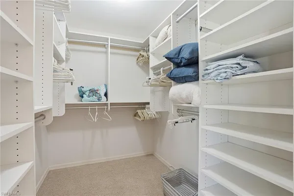 a view of walk in closet with clothes and shoes