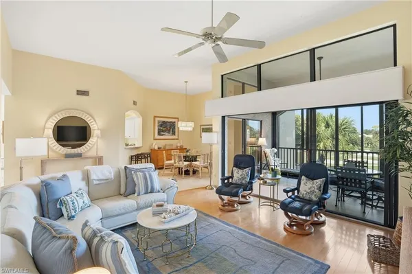 a living room with furniture and floor to ceiling windows