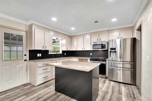 a kitchen with a refrigerator a sink and cabinets
