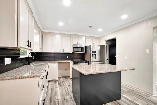 a kitchen with stainless steel appliances granite countertop a sink stove and refrigerator