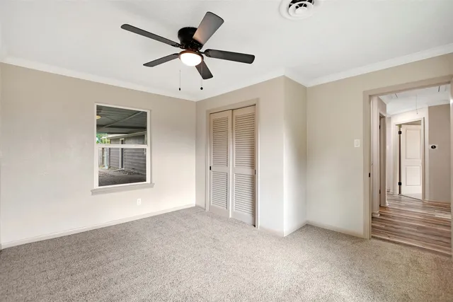 a view of an empty room with a ceiling fan