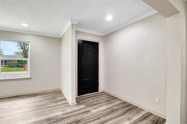 an empty room with wooden floor and window