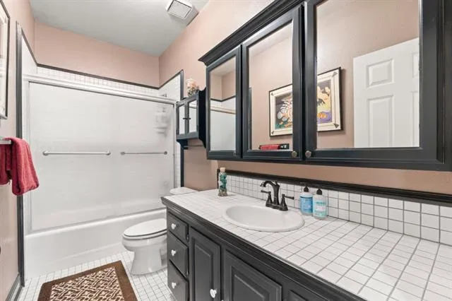 a bathroom with a tub a sink and a large mirror