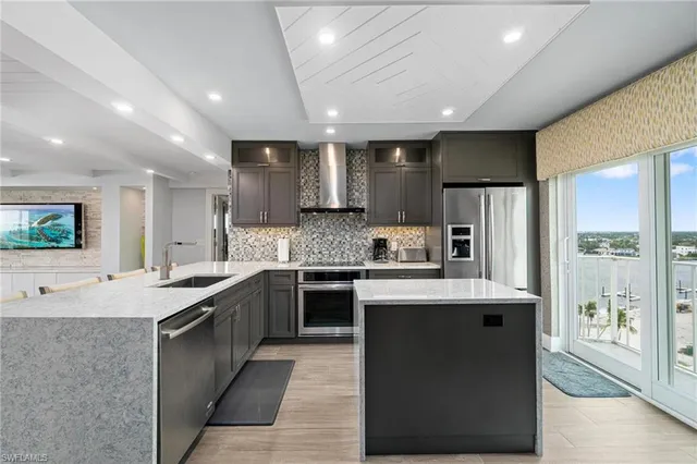 a large kitchen with kitchen island a island a sink a stove and a refrigerator