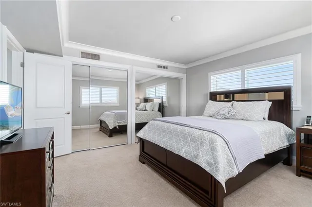 a bedroom with a bed and a view of kitchen