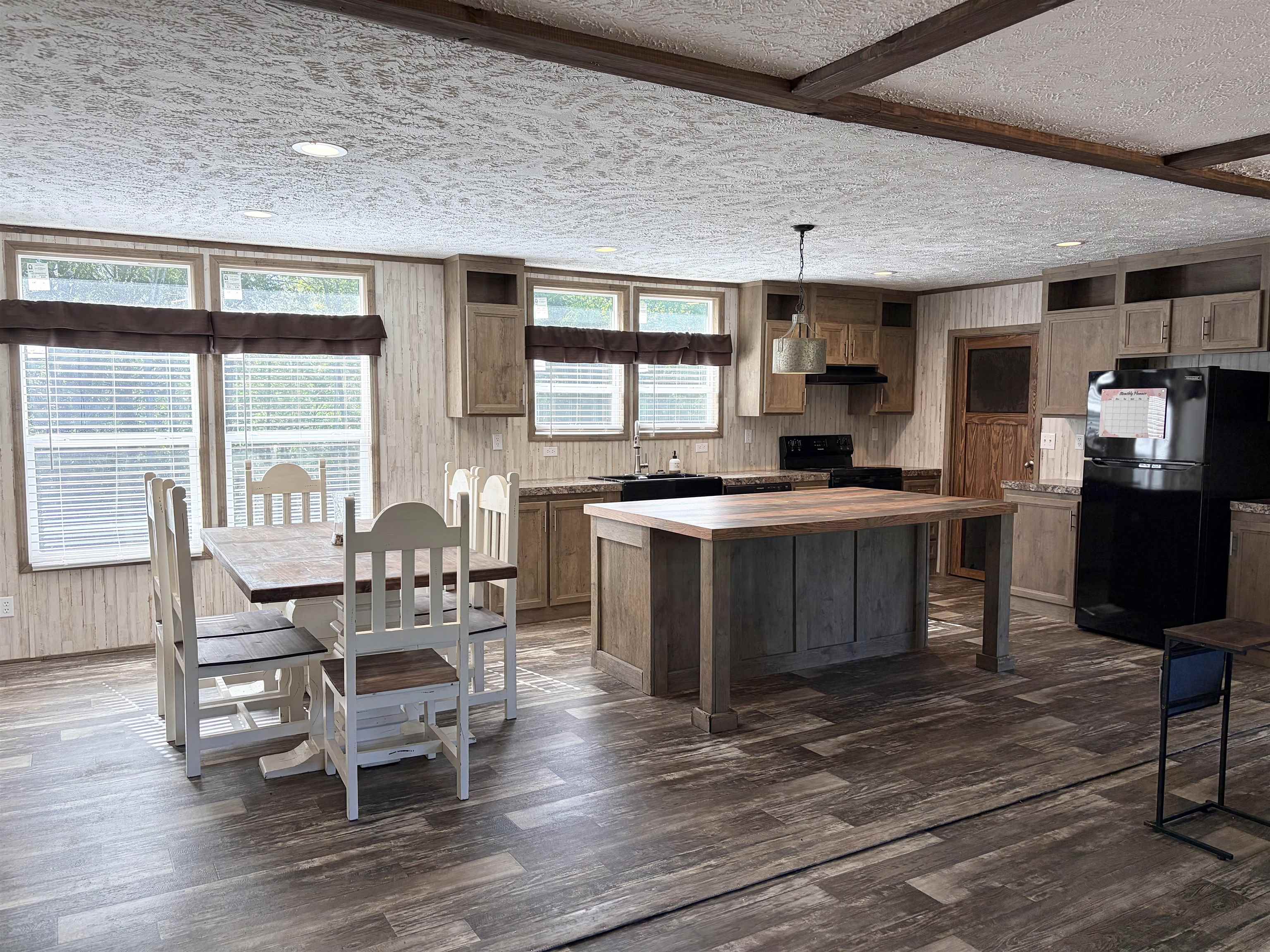 2030 Nubbin Ridge Road Middleton, TN 38052 - Photo 11 of 28 a kitchen with stainless steel appliances granite countertop a stove top oven a dining table and chairs with wooden floor