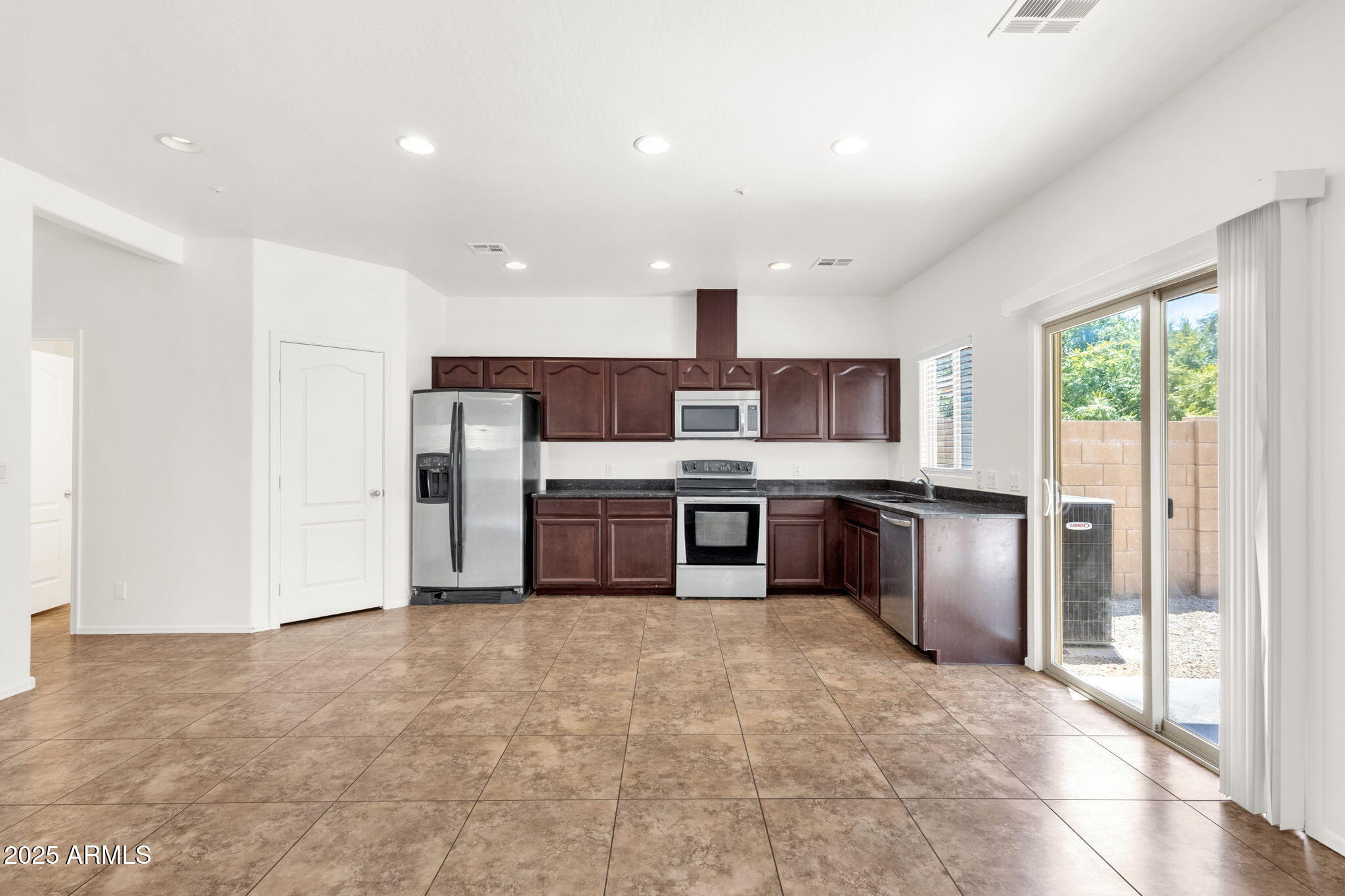 13414 North 87th Lane Peoria, AZ 85381 - Photo 11 of 45 a kitchen with stainless steel appliances a refrigerator and a sink