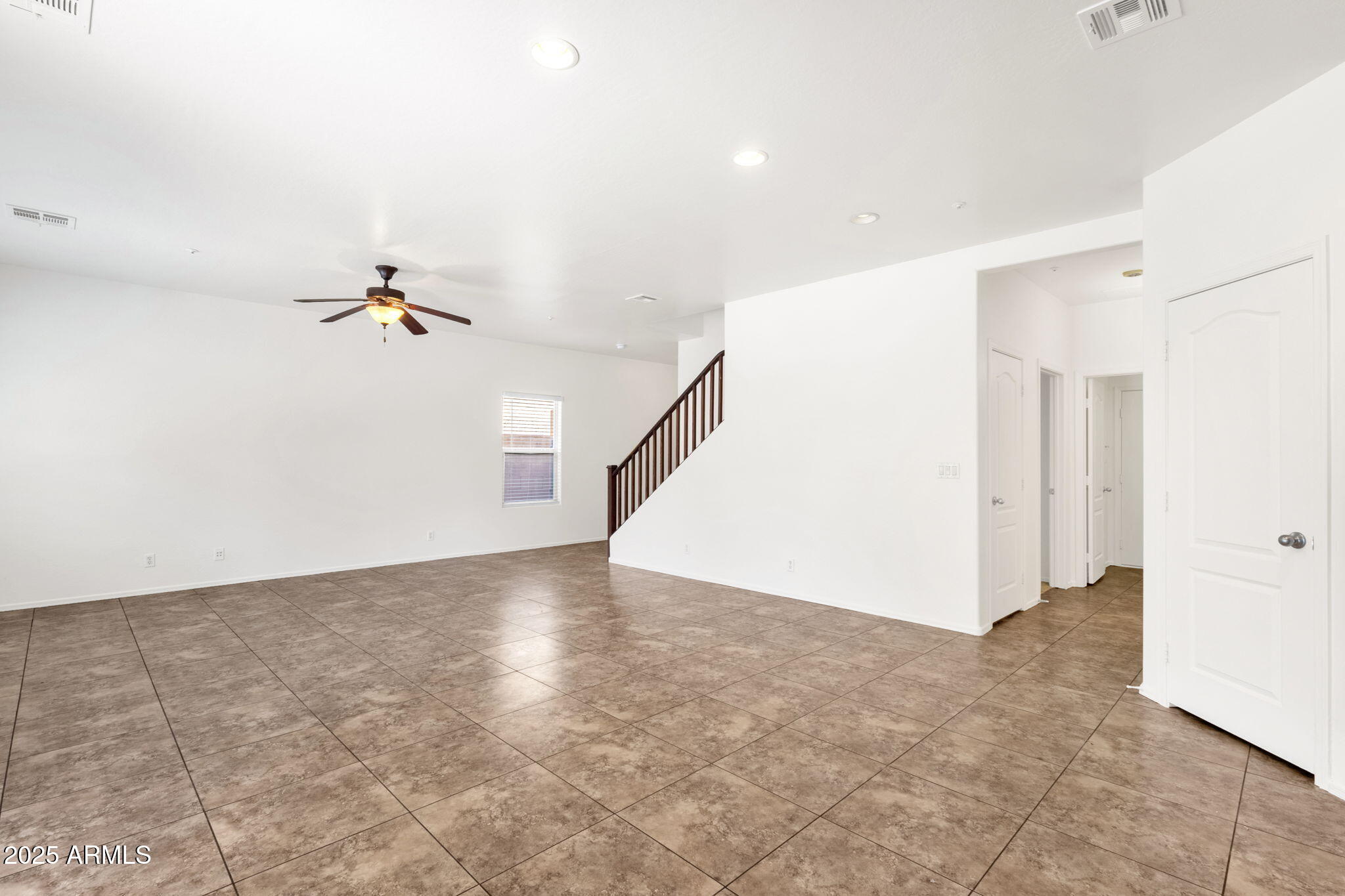 13414 North 87th Lane Peoria, AZ 85381 - Photo 13 of 45 a view of a livingroom with a ceiling fan and entryway