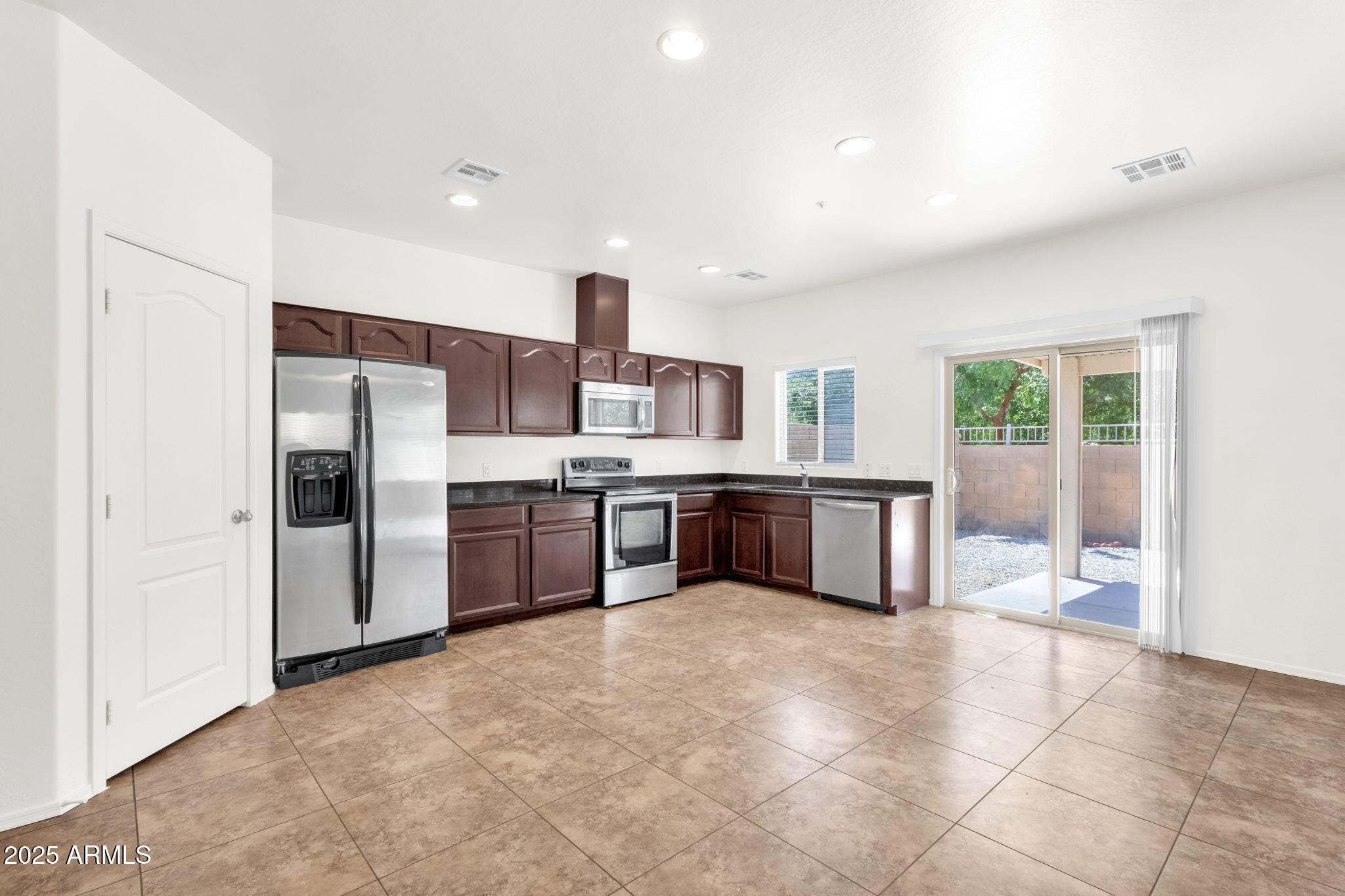 13414 North 87th Lane Peoria, AZ 85381 - Photo 10 of 45 a kitchen with stainless steel appliances a sink and a refrigerator