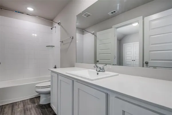 a bathroom with a sink a toilet and a large mirror
