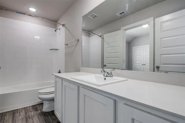 a bathroom with a sink a toilet and a large mirror