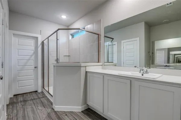 a bathroom with double vanity and a mirror