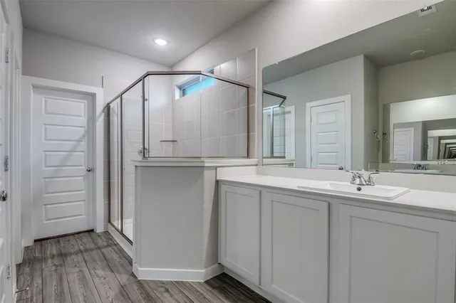 a bathroom with double vanity and a mirror