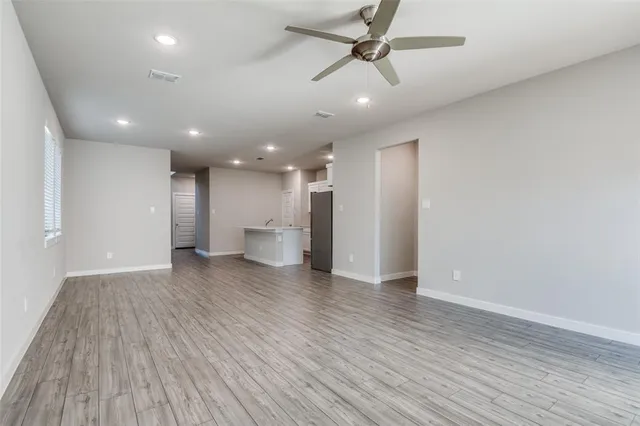 a view of a big room with wooden floor and windows