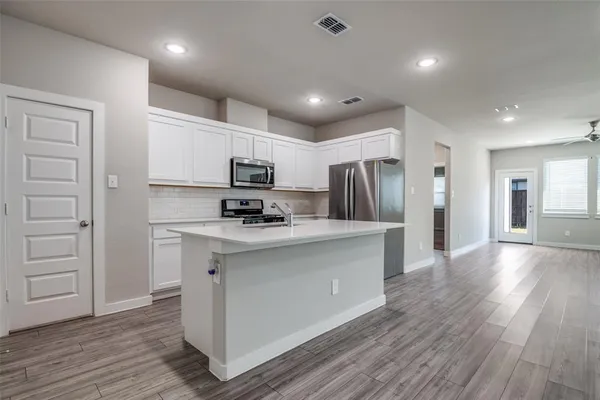 a kitchen with stainless steel appliances a refrigerator stove microwave and cabinets
