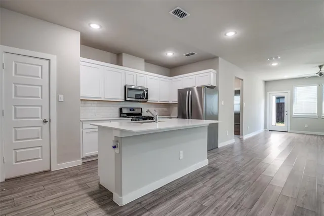 a kitchen with stainless steel appliances a refrigerator stove microwave and cabinets