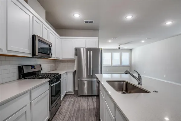 a kitchen filled a sink a microwave a stove and refrigerator