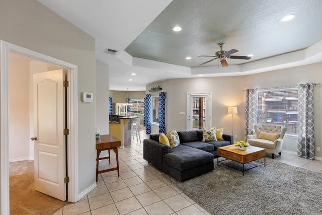 a living room with furniture a fireplace and a chandelier
