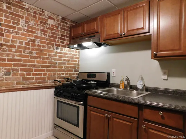 a kitchen with stainless steel appliances a sink a stove and cabinets